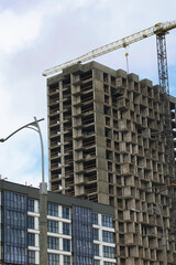 Construction of multi-storey buildings. Modern multi-storey building. Completed and under construction buildings. Construction cranes are visible.