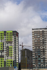 Construction of multi-storey buildings. Modern multi-storey building. Completed and under construction buildings. Construction cranes are visible.