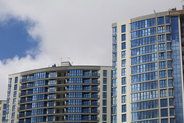 Construction of multi-storey buildings. Modern multi-storey building. Houses built of concrete and glass.