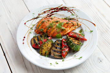 Grilled chicken breast and vegetables. In a plate. On a light background.