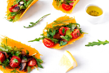 Tacos with cheese shells and vegetables on the white table. Vegetarian gluten free alternative of Mexican food appetizer