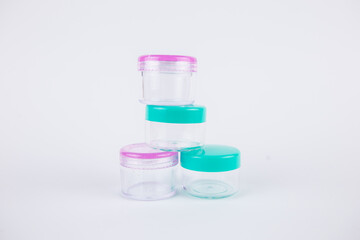 small plastic jars on a white background for cosmetics
