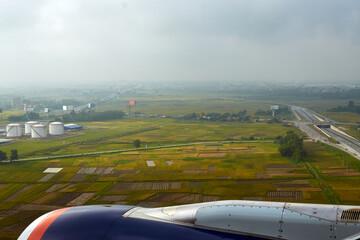green fields and cloudy sky from an airplane window. view from the airplane window