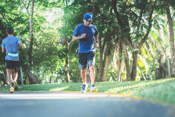 Blurred soft images of an Asian man are exercise by jogging for health on concrete roads in  the park, to exercise for healthy and sport concept.