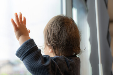 窓の外を眺める子供