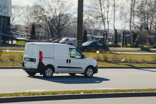 Fiat Doblo cargo. Compact commercial transport. White compact van is driving down the street. Motion blur. Riga, Latvia - 12 Apr 2022