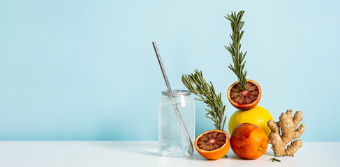 Tropical drink still life. Creative scene with flavored water in drink can citrus fruits, rosemary...