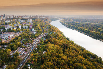 Aerial view of the picturesque autumn river in the suburbs of an industrial city and the transport...
