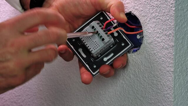 caen, France, April 2022. Light touch switch - socket assembly, electric wires connection. video 4k 25ftp