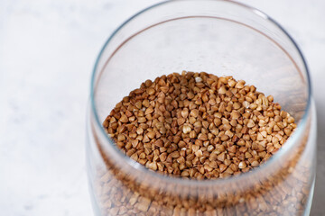 buckwheat groats in a glass jar on white background