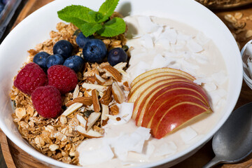 oat granola with apples and fresh berries, closeup