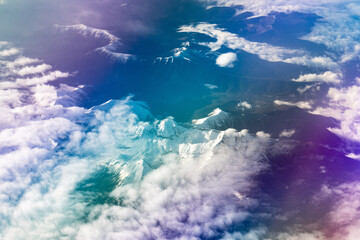 View form the airplane window on the mountains with rainbow glow