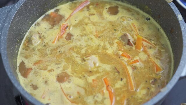 boiling zirvak for pilaf cooking in a cast-iron pot, top view
