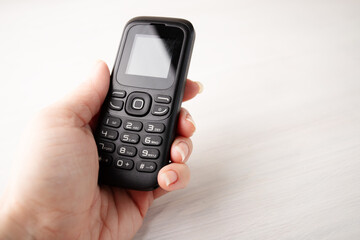 Simple cellphone in hand, with buttons, the old type