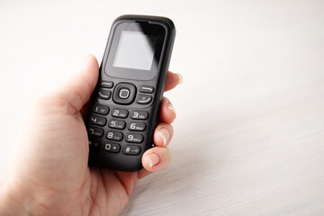 Obraz premium Simple cellphone in hand, with buttons, the old type