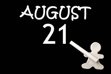 A small white plasticine man writing the date 21 August on a black board. Business concept. Education concept.