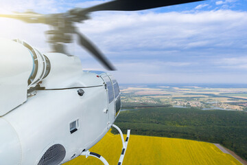 Helicopter flies over an agricultural field