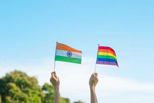 Hands Showing LGBTQ Rainbow And India Flag On Nature Background. Support Lesbian, Gay, Bisexual, Transgender And Queer Community And Pride Month Concept