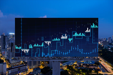 FOREX graph hologram on billboard, aerial night panoramic cityscape of Kuala Lumpur. KL is the developed location for stock market researchers in Malaysia, Asia. The concept of fundamental analysis