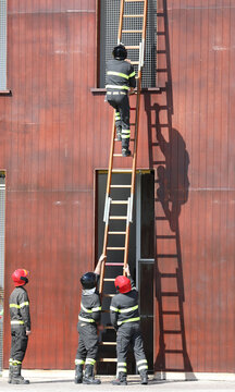 firefighters in action during the exercise in the fire station with the long ladder and the foreman timing