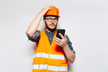 Portrait of serious engineer talking on smartphone, on white background.
