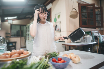 Young adult asian woman leisure with cooking in kitchen on day.