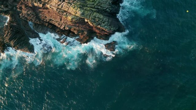 Aerial view of waves crashing on the rocks along the coast, Cornwall, United Kingdom.