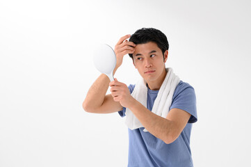 鏡で顔を確認する男性　メンズ美容