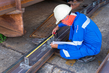Technicians are using a measuring tape to check the accuracy of the steel structure after assembly...