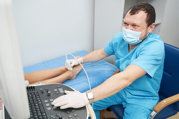 Health care professional examining the ankle joint with an ultrasound