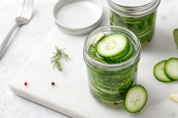 Lightly salted sliced cucumbers for the winter in jars with dill and garlic. Fermented vegetables.
