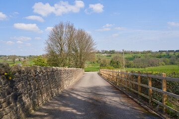 Fototapeta na wymiar Country lane with stone wall and wooden fence
