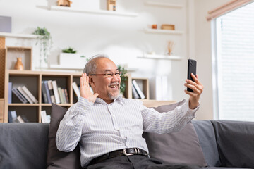 Asian elderly man making video call on smart phone, online call,  digital technology service consultation while staying at home. Smiling mature Video Call Conference talk chat online concept.