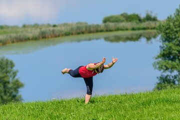 Junge Frau bei Pilates-Übungen in der Natur