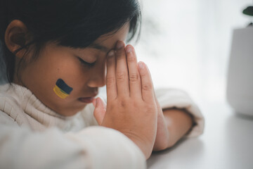 A child with the flag of Ukraine is crying. Sadness longing hope. Children's tears from the war....