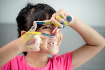 education, school, art and painitng concept - little student girl showing painted hands