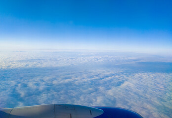 Beautiful view from the airplane window of the wing and the sky with clouds