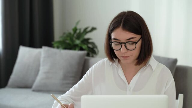 Pretty young woman psychotherapist with glasses smilling beginning online consultation with client at videochat in home. People and psychology concept. distance counseling in pandemic. 4k footage