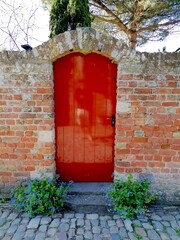 rote Tür in einer Umfriedung © Jogerken