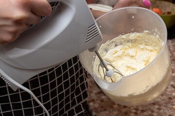 The process of whipping cream with mixer. Selective focus. Picture for articles about food, confectionery, recipes.