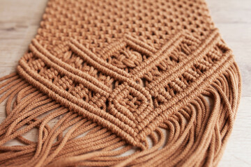 Fototapeta na wymiar Handmade macrame. Macrame braiding and cotton threads. Female hobby. ECO friendly modern knitting DIY natural decoration concept in the interior. Makrame pattern close up.
