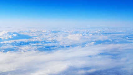 Fototapeta premium Beautiful view from the plane to the blue sky with white clouds