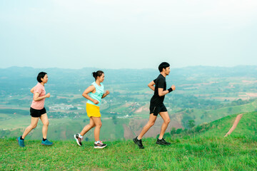 Asian man and woman trail runner running. On the high mountains, beautiful scenery. It's a trail running practice. on a bright day Behind is a beautiful mountain view.