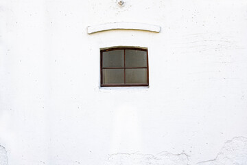Małe drewniane okno brązowe na starej ścianie białej - stary mur - biała ściana retro - biały mur zewnętrzny