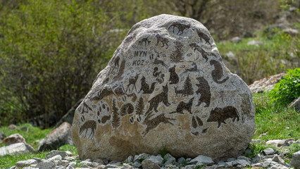 A large stone with animal drawings