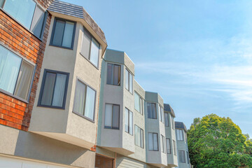 Low angle view of townhouses with bay windows and wood shingle sidings in San Francisco, California