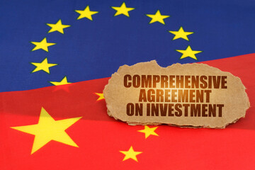 On the flags of China and the European Union lies a cardboard plate with the inscription - CAI