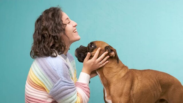 Woman stroking and hugging her boxer dog.