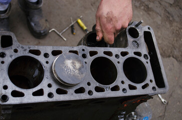 An auto mechanic is working on a car engine in a mechanics garage. Repair service. authentic close-up shot. VAZ 2106