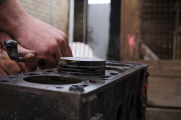 An auto mechanic is working on a car engine in a mechanics garage. Repair service. authentic close-up shot. VAZ 2106